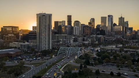 DXP001_000090 - Aerial stock photo of The city's skyline behind a residential skyscraper and a bridge at sunrise in Downtown Denver, Colorado