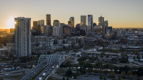 DXP001_000096 - Aerial stock photo of Sun rising behind residential skyscraper and city's skyline in Downtown Denver, Colorado