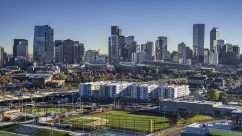 DXP001_000124 - Aerial stock photo of Towering skyscrapers of city skyline seen from baseball field by apartment building, Downtown Denver, Colorado