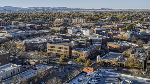 Shops and brick office buildings lining a busy town road in Fort Collins, Colorado Aerial Stock Photos | DXP001_000252