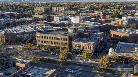 A brick office building and shop beside a town road in Fort Collins, Colorado Aerial Stock Photos | DXP001_000253