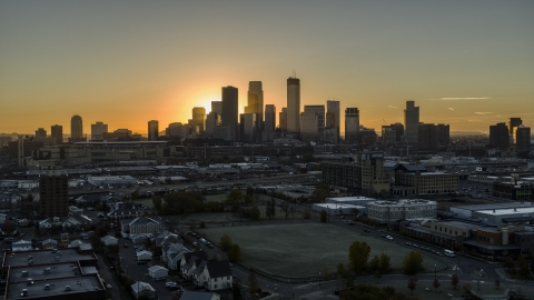 DXP001_000258 - Aerial stock photo of The bright sun behind tall skyscrapers in the city's skyline at sunrise in Downtown Minneapolis, Minnesota