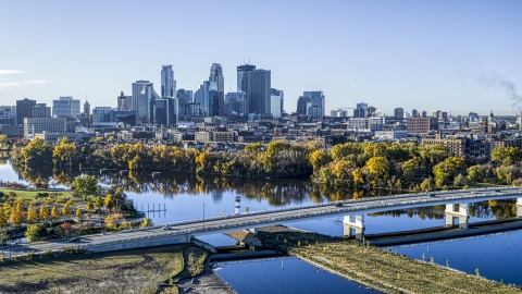 DXP001_000363 - Aerial stock photo of The city's skyline seen from a bridge spanning the tree-lined river, Downtown Minneapolis, Minnesota