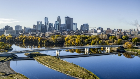 DXP001_000364 - Aerial stock photo of The city's skyline in the distance, seen from a bridge spanning the tree-lined river, Downtown Minneapolis, Minnesota