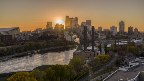 DXP001_000422 - Aerial stock photo of The setting sun behind the skyline across the river, seen from a power plant, Downtown Minneapolis, Minnesota