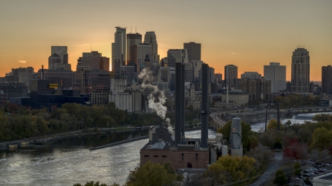 DXP001_000431 - Aerial stock photo of Power plant in foreground and city skyline on the other side of the river at sunset, Downtown Minneapolis, Minnesota