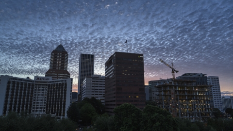 DXP001_014_0010 - Aerial stock photo of Hotel and office building with skyscrapers in the background at sunset in Downtown Portland, Oregon