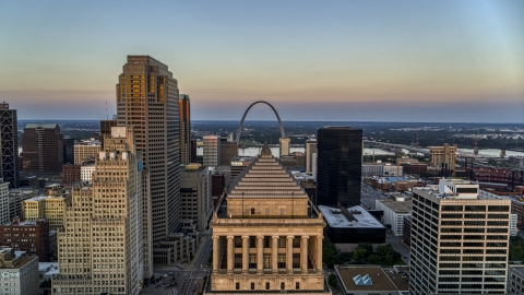 DXP001_036_0005 - Aerial stock photo of A view over the top of a courthouse to the Gateway Arch at twilight, Downtown St. Louis, Missouri