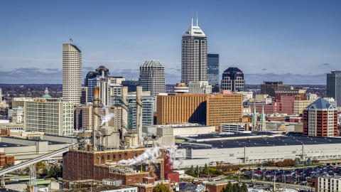 A factory with smoke stacks and the city's skyline in Downtown Indianapolis, Indiana Aerial Stock Photos | DXP001_089_0008