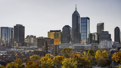 The towering skyscrapers in the city's skyline in Downtown Indianapolis, Indiana seen from trees Aerial Stock Photos | DXP001_090_0011