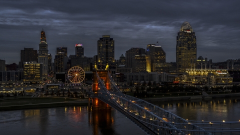 DXP001_098_0004 - Aerial stock photo of The Roebling Bridge lit up at twilight by the city skyline, Downtown Cincinnati, Ohio