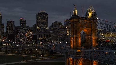 DXP001_098_0008 - Aerial stock photo of City skyline, Ferris wheel and Roebling Bridge lit up at twilight, Downtown Cincinnati, Ohio