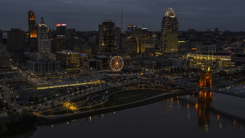 DXP001_098_0010 - Aerial stock photo of The lights of city's downtown skyline and bridge at twilight, seen from the river, Downtown Cincinnati, Ohio