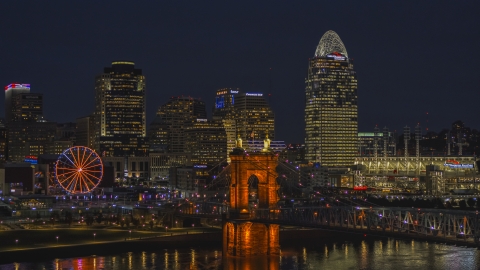 DXP001_098_0019 - Aerial stock photo of The bridge, tall skyscrapers and Ferris wheel at night in Downtown Cincinnati, Ohio