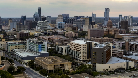 DXP002_105_0010 - Aerial stock photo of A hospital in the foreground, with skyscrapers and capitol dome in distance at sunset in Downtown Austin, Texas