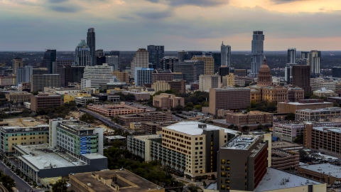 DXP002_105_0011 - Aerial stock photo of A hospital, with skyscrapers and capitol dome in distance at sunset in Downtown Austin, Texas