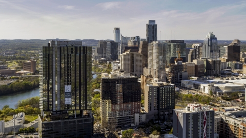 DXP002_108_0015 - Aerial stock photo of The city's skyline behind a high-rise near Lady Bird Lake in Downtown Austin, Texas