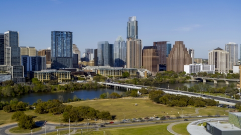 DXP002_109_0005 - Aerial stock photo of The city's skyline on the opposite side of Lady Bird Lake seen from a street near bridge, Downtown Austin, Texas