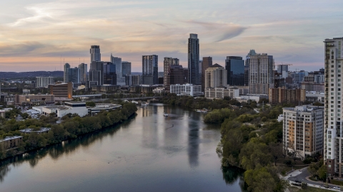 DXP002_110_0006 - Aerial stock photo of The waterfront skyline by Lady Bird Lake at sunset in Downtown Austin, Texas