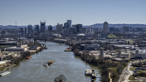 DXP002_112_0008 - Aerial stock photo of A barge sailing the river toward the city's skyline, Downtown Nashville, Tennessee