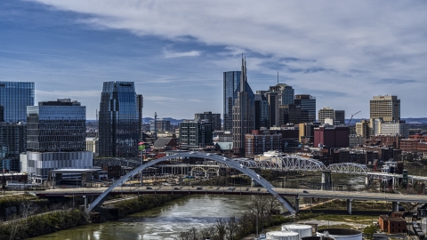 A river and bridge, skyscrapers in the background in Downtown Nashville, Tennessee Aerial Stock Photos | DXP002_116_0011