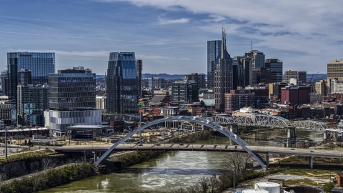 A bridge, and skyscrapers near the Cumberland River in Downtown Nashville, Tennessee Aerial Stock Photos | DXP002_116_0012