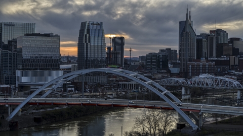 A tall skyscraper seen from a bridge on the river at sunset, Downtown Nashville, Tennessee Aerial Stock Photos | DXP002_120_0009