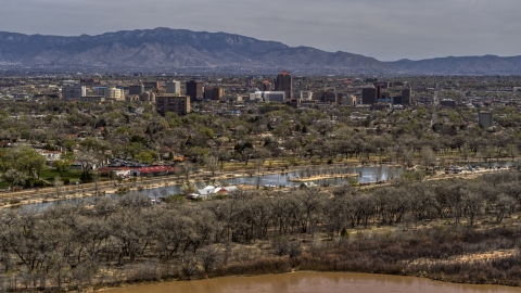 High-rise office buildings seen while flying by park and Rio Grande, Downtown Albuquerque, New Mexico Aerial Stock Photos | DXP002_124_0008