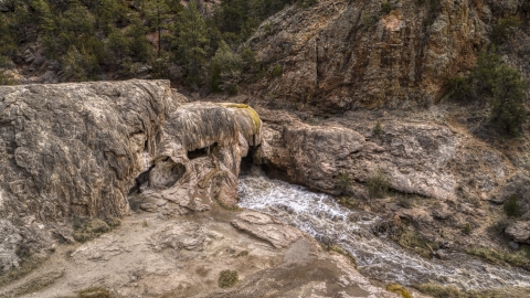 DXP002_129_0004 - Aerial stock photo of River rapids flowing through Soda Dam rock formation in the mountains in New Mexico