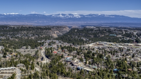 DXP002_134_0004 - Aerial stock photo of A wide view of distant mountains seen from homes near mesas and canyons in Los Alamos, New Mexico