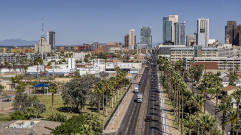 DXP002_137_0002 - Aerial stock photo of Palm trees at city park and street leading to tall office buildings in Downtown Phoenix, Arizona