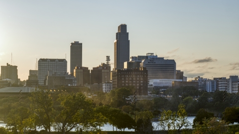 DXP002_172_0008 - Aerial stock photo of A tall skyscraper seen from a city park at sunset, Downtown Omaha, Nebraska