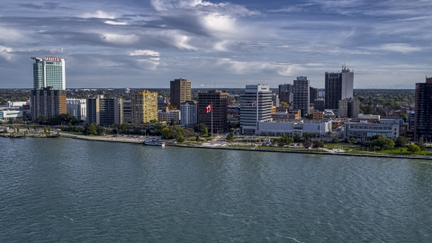 A view of office buildings and Canadian flag by the river in Windsor, Ontario, Canada Aerial Stock Photos | DXP002_196_0004