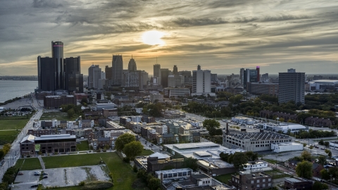 DXP002_197_0001 - Aerial stock photo of The setting sun behind clouds above the Downtown Detroit skyline, Michigan