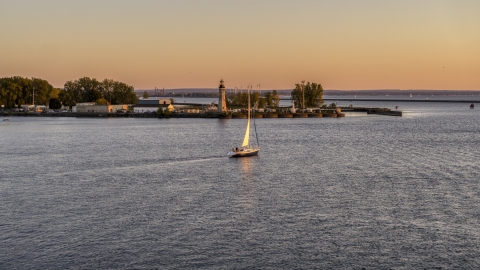 A sailboat on Lake Erie near a lighthouse at sunset, Buffalo, New York Aerial Stock Photos | DXP002_204_0008