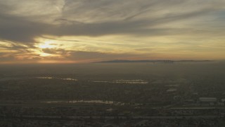 5K aerial stock footage of setting sun behind clouds and Downtown Los Angeles skyline seen from Pico Rivera, California Aerial Stock Footage | AF0001_000980