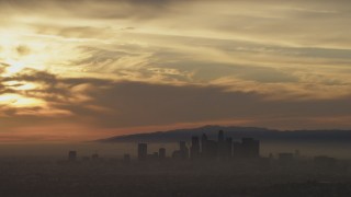 5K aerial stock footage of sunset-lit clouds above the Downtown Los Angeles skyline in haze, California Aerial Stock Footage | AF0001_000987