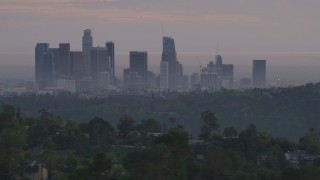 5K aerial stock footage of Downtown Los Angeles skyline seen while flying behind green hills and Dodger Stadium at twilight, California Aerial Stock Footage | AF0001_000999