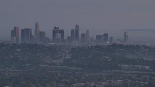 5K aerial stock footage of a view of Downtown Los Angeles skyline behind hillside houses in Silver Lake at twilight, California Aerial Stock Footage | AF0001_001005