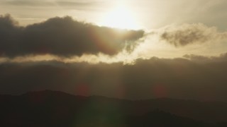 8K aerial stock footage of setting sun behind clouds and mountain ridges in Southern California Aerial Stock Footage | AF0001_001031