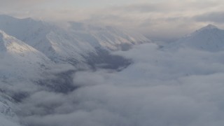 4K aerial stock footage valley between snow covered peaks, low clouds, Chugach National Forest, Alaska Aerial Stock Footage | AK0001_0012