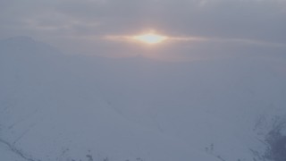 4K aerial stock footage approaching sun peeking through low clouds, Chugach Mountains, Alaska, sunset Aerial Stock Footage | AK0001_0081