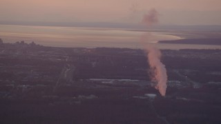 4K aerial stock footage flying by power plant, approaching Downtown Anchorage, Alaska, sunset Aerial Stock Footage | AK0001_0098