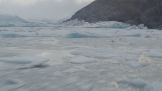 AK0001_0115 - 4K aerial stock footage flying low over the icy Knik River, approaching Knik Glacier, Alaska