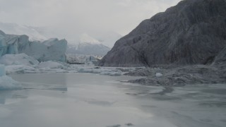 4K aerial stock footage flying low over icy Knik River, tilt up, revealing Knik Glacier, Alaska Aerial Stock Footage | AK0001_0116