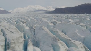 AK0001_0134 - 4K aerial stock footage flying low over Knik Glacier, Chugach Mountains in the distance, Knik Glacier, Alaska