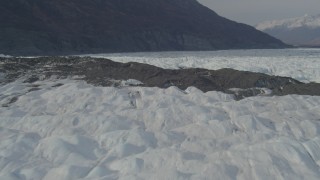 AK0001_0145 - 4K aerial stock footage fly over surface of Knik Glacier, approach helicopter flying by, Knik Glacier, Alaska