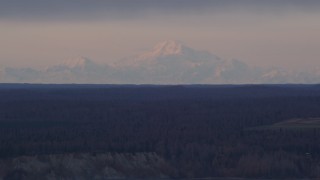 4K aerial stock footage flying by forest countryside, snow capped mountains, Point MacKenzie, Alaska Aerial Stock Footage | AK0001_0163