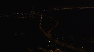 4K aerial stock footage flying along Glenn Highway, approaching Hiland Mountains Correctional Center, Eagle River, Alaska, night Aerial Stock Footage | AK0001_0201