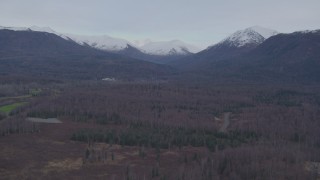 4K aerial stock footage flying over forested foothills, approaching snow capped Chugach Mountains, Alaska Aerial Stock Footage | AK0001_0247